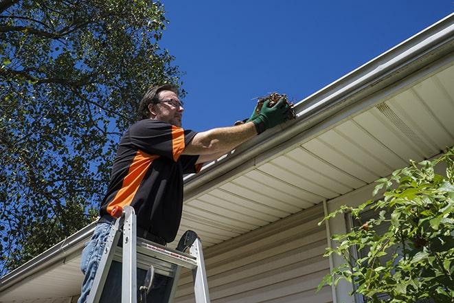 a skilled technician repairing a gutter on a house in Coventry, RI